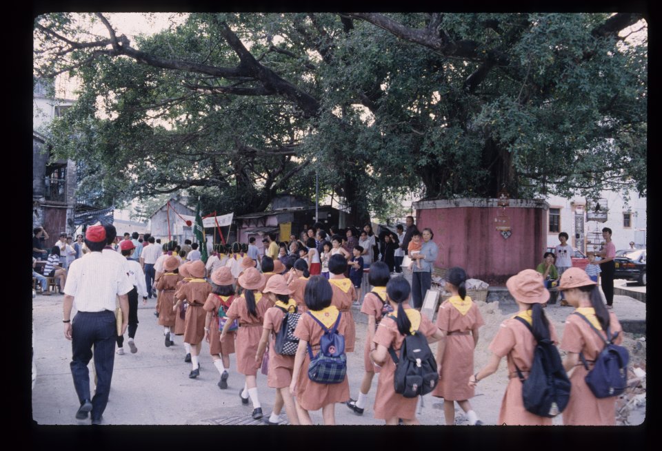 Liu clan children walk in procession past the banyan tree.